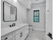 Modern bathroom featuring a large vanity with black hardware, sleek mirror, and gray tiled floor at 3832 Noremac Dr, Raleigh, NC 27612