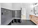 This bathroom features a gray bench, wood cabinets, dual sinks, and black hardware at 3832 Noremac Dr, Raleigh, NC 27612