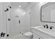 Bathroom features glass shower with white tile, dark hardware, white vanity, and white commode at 3832 Noremac Dr, Raleigh, NC 27612