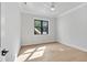 Bright bedroom features light hardwood floors, a ceiling fan, and a large window with a backyard view at 3832 Noremac Dr, Raleigh, NC 27612