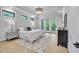 Bright primary bedroom with tray ceiling, an area rug and doors leading to a private outdoor space at 3832 Noremac Dr, Raleigh, NC 27612