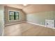 Bedroom with hardwood floors, floral wallpaper, a window, and a white closet door at 3832 Noremac Dr, Raleigh, NC 27612