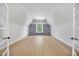 Attic bonus room with hardwood floors, built-in shelves, and natural light, creating a versatile and functional space at 3832 Noremac Dr, Raleigh, NC 27612