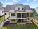 Two-story home exterior featuring a screened porch, deck, stairs, and a lush, green lawn at 3832 Noremac Dr, Raleigh, NC 27612