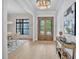 Bright foyer with beautiful wood floors, a decorative table, and a view to the dining room at 3832 Noremac Dr, Raleigh, NC 27612