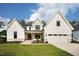 Attractive two-story home boasting a modern white facade, stone accents, and a green lawn at 3832 Noremac Dr, Raleigh, NC 27612
