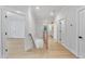 Bright hallway with hardwood floors and white doors, offering a clean and inviting transition between different areas of the home at 3832 Noremac Dr, Raleigh, NC 27612