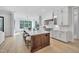 Spacious kitchen with a center island, wood floors, and stainless steel appliances, connecting to the breakfast area at 3832 Noremac Dr, Raleigh, NC 27612