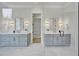 Main bathroom features double vanity, stunning light fixtures, and glass-enclosed shower at 3832 Noremac Dr, Raleigh, NC 27612