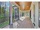 Inviting screened porch with wood ceiling, ceiling fan, black metal railing, and beautiful view of the trees at 3832 Noremac Dr, Raleigh, NC 27612