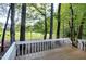 Wooden deck with white railing and views of trees and foliage in backyard at 3900 Inkberry Ct, Apex, NC 27539