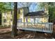 Backyard wooden deck and yellow home with trees and foliage in background at 3900 Inkberry Ct, Apex, NC 27539