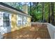 Backyard deck with yellow siding, white trim, and view of trees and foliage at 3900 Inkberry Ct, Apex, NC 27539