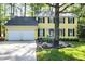 Charming yellow two-story home featuring a two-car garage and a beautifully landscaped front yard at 3900 Inkberry Ct, Apex, NC 27539