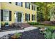Two-story yellow home featuring a landscaped front yard and a walkway leading to the front door at 3900 Inkberry Ct, Apex, NC 27539