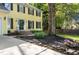 Two-story yellow home featuring a landscaped front yard with flowers and rock borders at 3900 Inkberry Ct, Apex, NC 27539