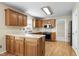 View of well-lit kitchen featuring wood cabinets and modern stainless steel appliances at 3900 Inkberry Ct, Apex, NC 27539