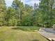 Lush backyard with a well-manicured lawn and stone landscaping offers a serene outdoor space at 3900 Maplefield Dr, Raleigh, NC 27613