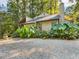 Charming home with gravel driveway and lush, tropical landscaping at 3900 Maplefield Dr, Raleigh, NC 27613