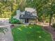 Eye-level view of home with lush lawn and landscaping, and gravel driveway at 3900 Maplefield Dr, Raleigh, NC 27613