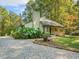 Inviting home exterior with mature landscaping, a charming front porch, and a welcoming gravel driveway at 3900 Maplefield Dr, Raleigh, NC 27613