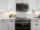 A modern kitchen features stainless steel appliances, white cabinets, and a white tile backsplash at 3900 Maplefield Dr, Raleigh, NC 27613