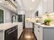 A bright kitchen features white cabinets, stainless steel appliances, and a white tile backsplash at 3900 Maplefield Dr, Raleigh, NC 27613