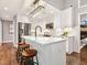Bright kitchen with an island, white cabinetry, stainless steel appliances, and hardwood flooring at 3900 Maplefield Dr, Raleigh, NC 27613