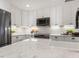 A bright kitchen features white cabinets, stainless steel appliances, and a white tile backsplash at 3900 Maplefield Dr, Raleigh, NC 27613