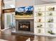 Living room features a fireplace with a large flatscreen above and custom built-in shelving at 3900 Maplefield Dr, Raleigh, NC 27613