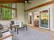 Screened porch with an outdoor seating area, a view to the forest and open access to the kitchen at 3900 Maplefield Dr, Raleigh, NC 27613