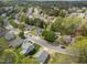 Aerial view captures a peaceful residential street lined with various homes surrounded by mature trees and green lawns at 420 Feldspar Way, Durham, NC 27703