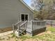 View of a wooden back deck with stairs, leading to the backyard with mature trees and wood fence at 420 Feldspar Way, Durham, NC 27703
