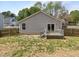A view of the backyard and back of the home with a small deck and sliding glass door at 420 Feldspar Way, Durham, NC 27703