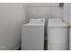 Bright laundry room featuring a white washer and dryer with overhead shelving for convenient storage at 420 Feldspar Way, Durham, NC 27703