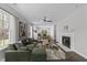 Bright living room featuring a cozy fireplace, ceiling fan, and view to adjacent dining area at 420 Feldspar Way, Durham, NC 27703
