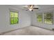 This is a bright bedroom with neutral walls and carpet, complemented by natural light from two windows at 4523 Tarkiln Pl, Wake Forest, NC 27587