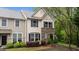 Well-maintained exterior of a two-story townhome with stone accents and manicured shrubs at 4523 Tarkiln Pl, Wake Forest, NC 27587