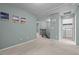 A carpeted hallway with artwork on the walls, leading to a laundry room and staircase at 4523 Tarkiln Pl, Wake Forest, NC 27587