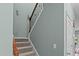 Carpeted staircase with wooden railing and wrought iron balusters at 4523 Tarkiln Pl, Wake Forest, NC 27587