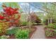 Lush garden with mulch beds, mature trees, and a meandering stone pathway at 463 Old Piedmont Cir, Chapel Hill, NC 27516