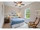 This quaint bedroom features a ceiling fan, a rocking chair, and lots of natural light at 463 Old Piedmont Cir, Chapel Hill, NC 27516