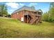 Brick home exterior featuring a wooden deck and staircase at 48 Arabella Ln, Clayton, NC 27520