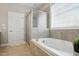 Bright bathroom featuring tile floors, a soaking tub, and a glass shower at 48 Arabella Ln, Clayton, NC 27520