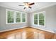 Bedroom with hardwood flooring and large windows offering views of mature trees and natural light at 48 Arabella Ln, Clayton, NC 27520