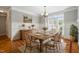 Bright dining room with wood floors, wainscoting, chandelier, and a large window at 48 Arabella Ln, Clayton, NC 27520