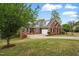 A charming red brick home with attached garage, set on a well-maintained sloping lawn at 48 Arabella Ln, Clayton, NC 27520