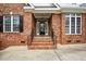Close-up view of a classic brick home's front entrance, showcasing a detailed glass door and brick steps at 48 Arabella Ln, Clayton, NC 27520