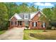 Inviting brick home featuring black shutters, dormer windows and a well-manicured front yard at 48 Arabella Ln, Clayton, NC 27520