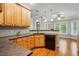 Kitchen featuring wood cabinetry, dark countertops, and views into the living area at 48 Arabella Ln, Clayton, NC 27520
